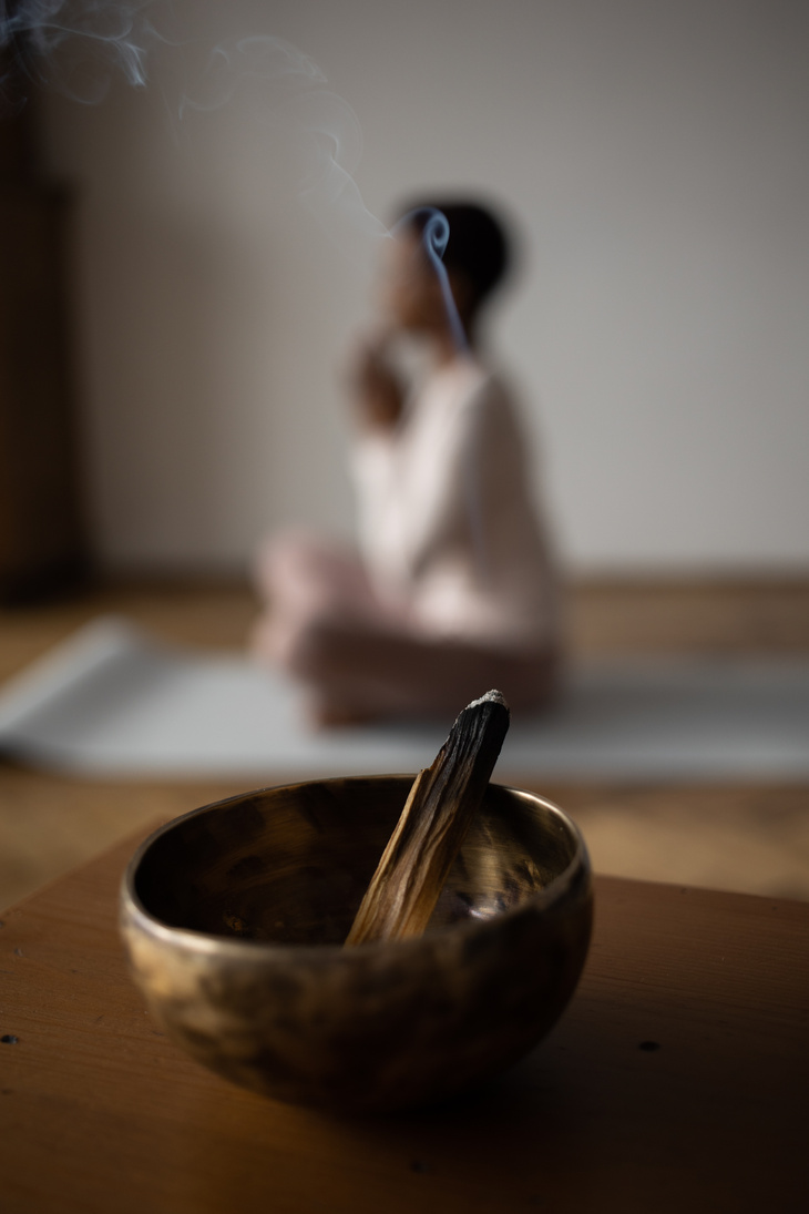 Burning Incense and a Woman Practising Yoga in the Background 